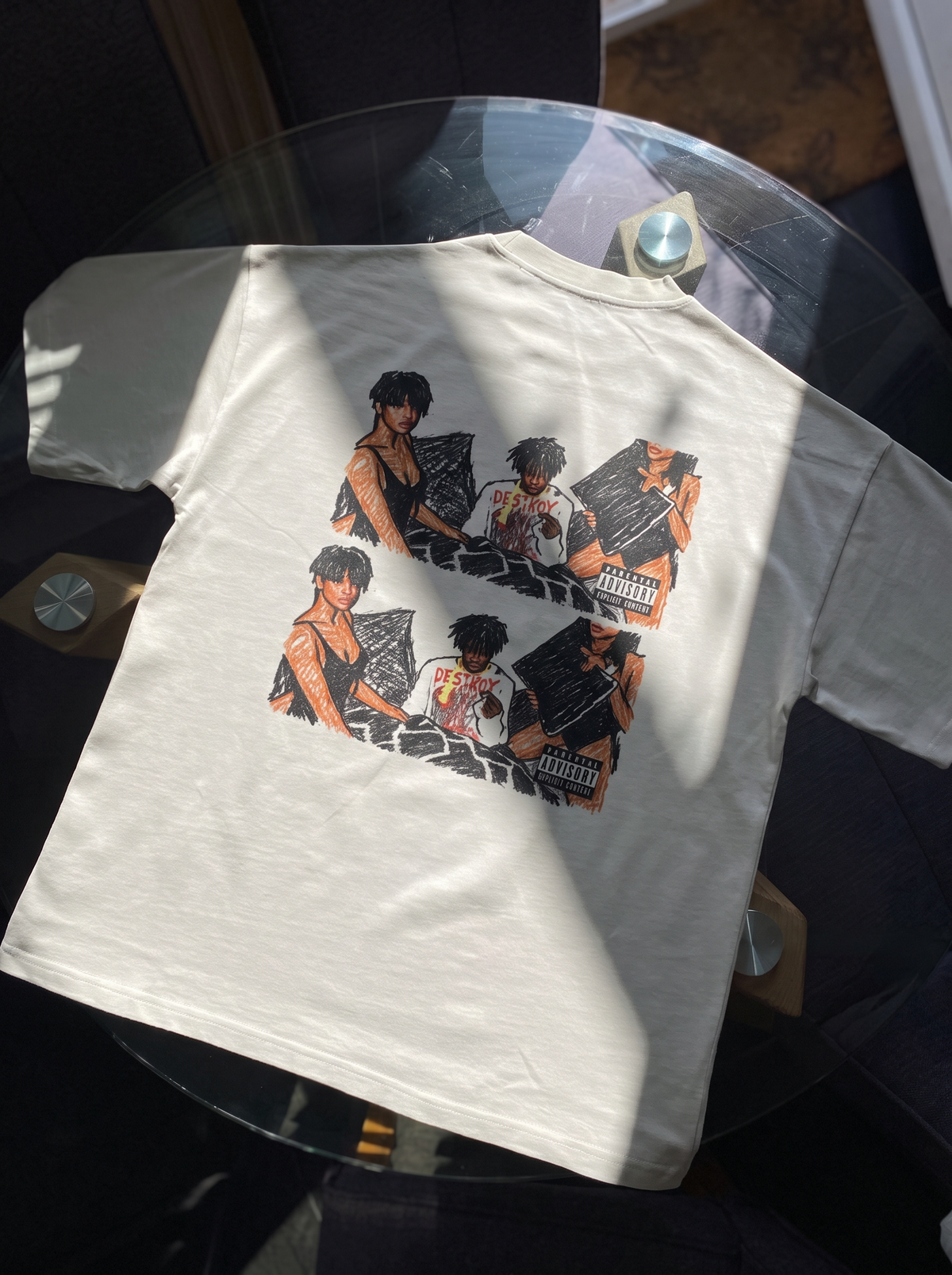Playboi Carti tee, back print laid flat on a glass table