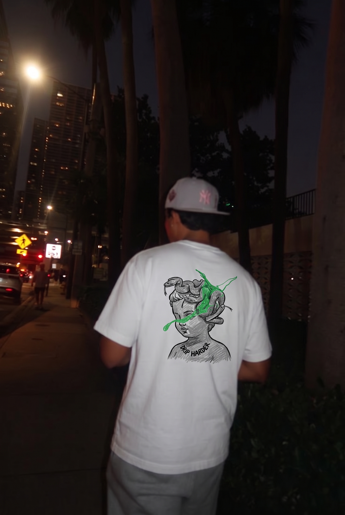 Drip Harder tee, back print worn on a city street at night