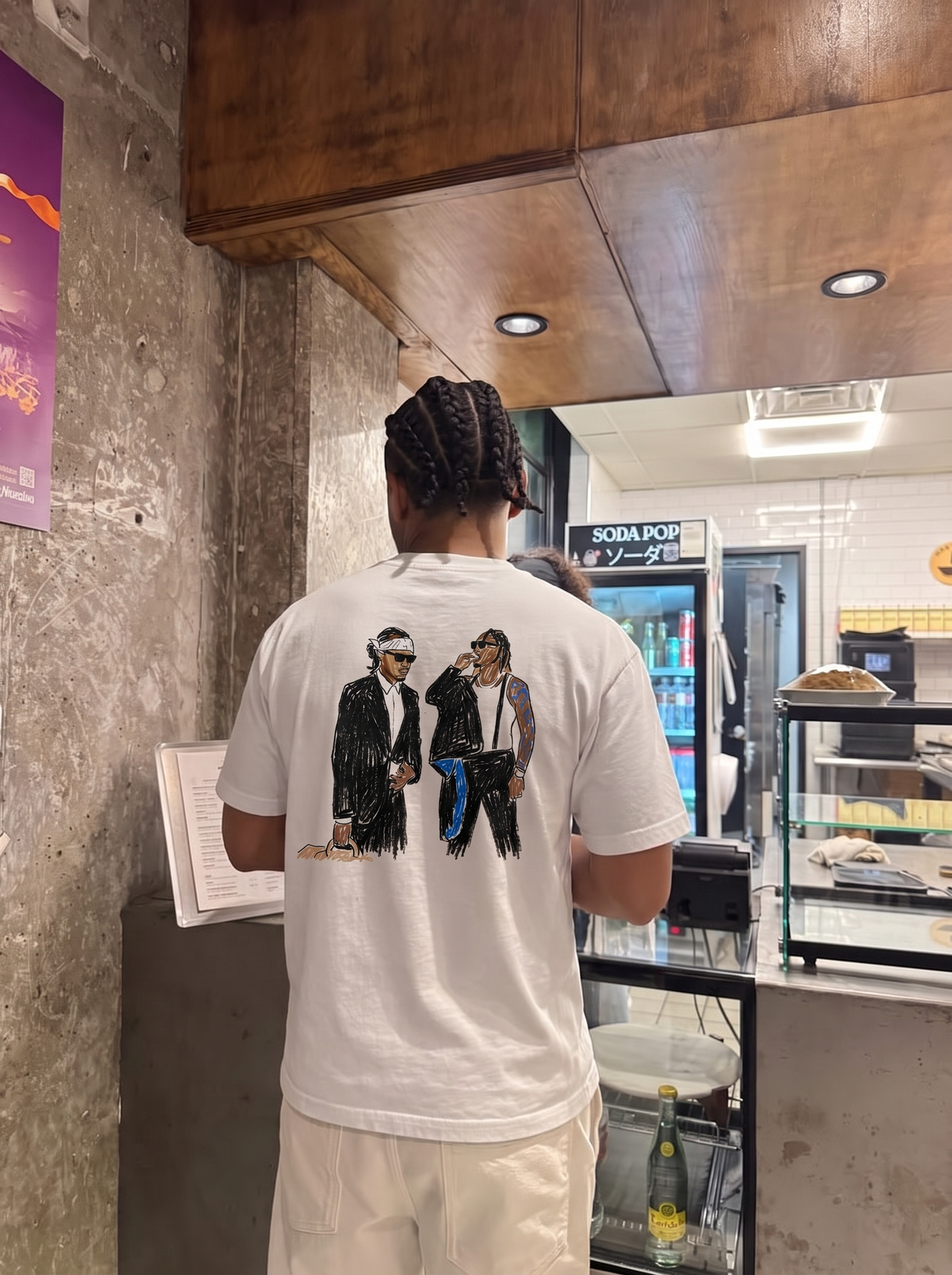 We Don't Trust You tee, back print worn in a café