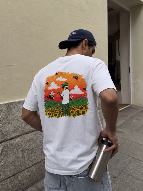 Flower Boy tee, back print worn against a cream wall