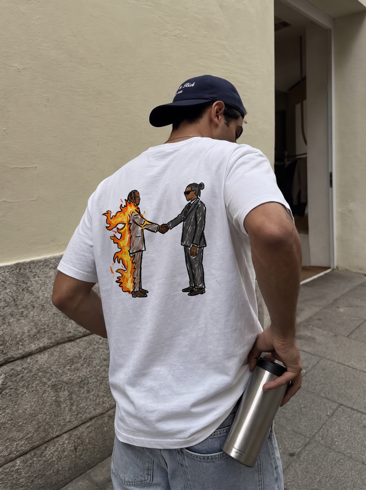 Heroes & Villains tee, back print worn against a cream wall