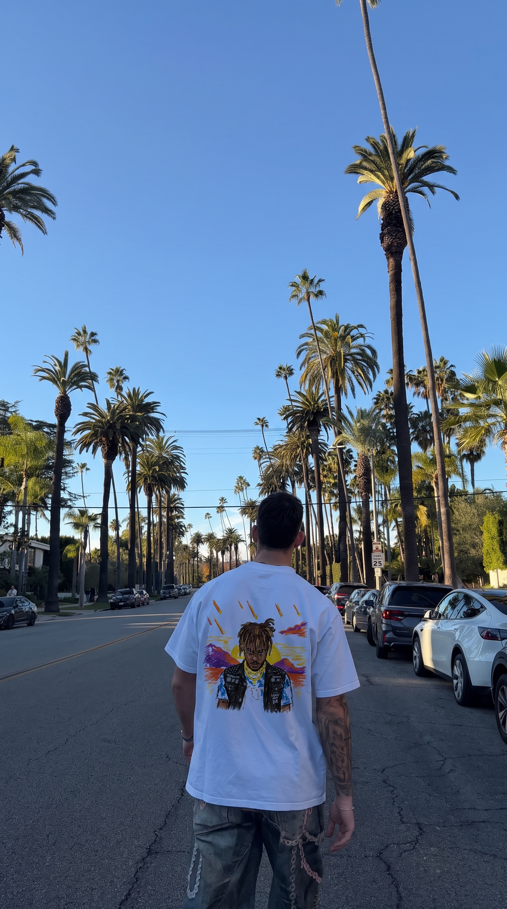 Legends Never Die tee, back print worn on a palm-lined street